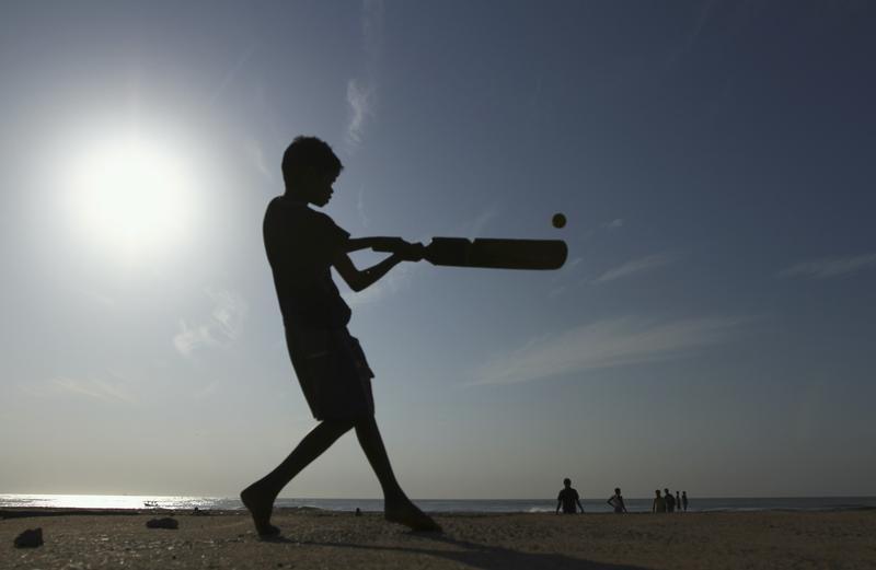 A boy playing cricket