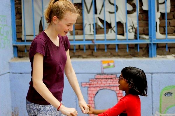 julia with kid while volunteering in India